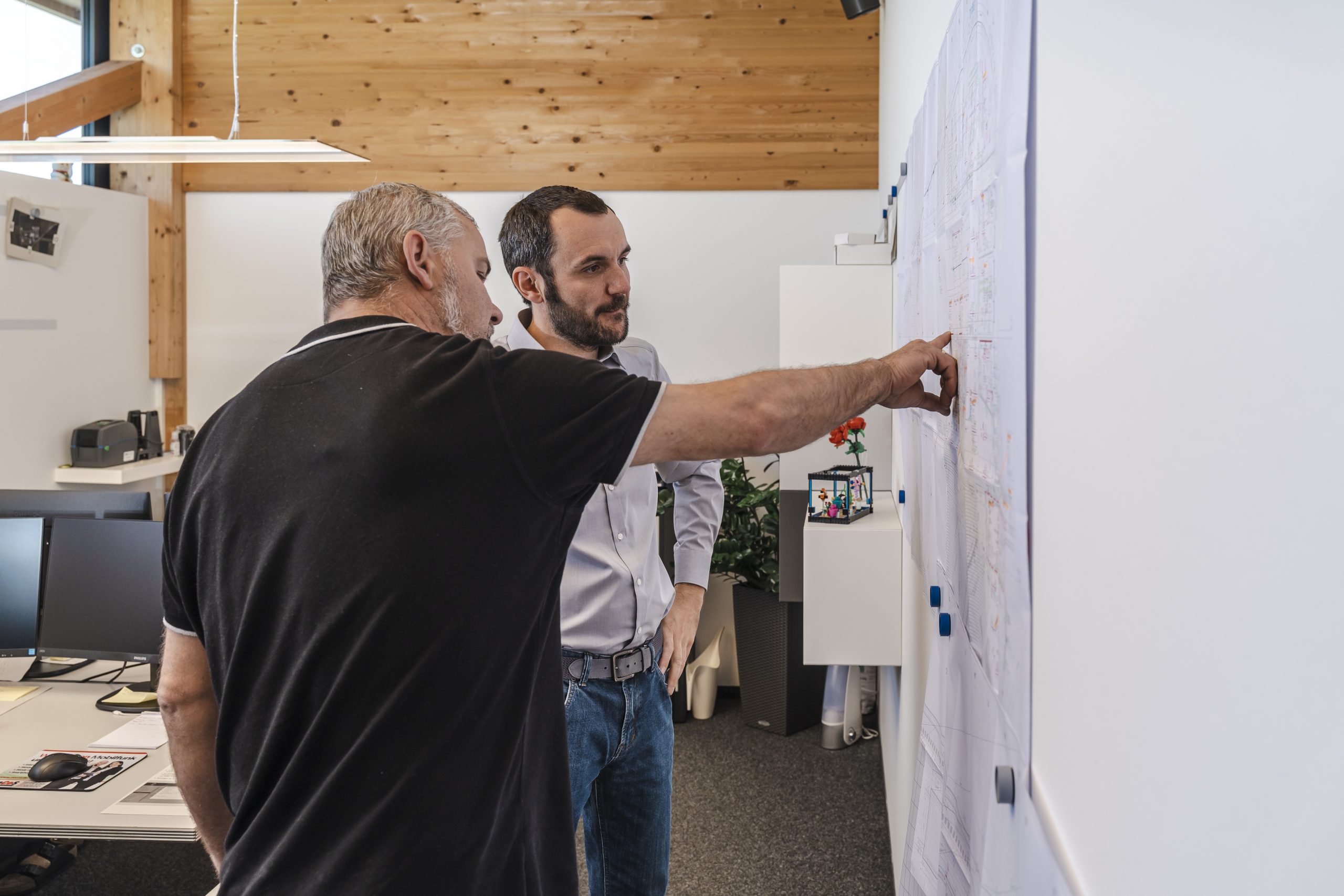 Projektleiter und Geschäftsführer der Gronover Elektrotechnik stehen diskutierend vor einem Projektplan